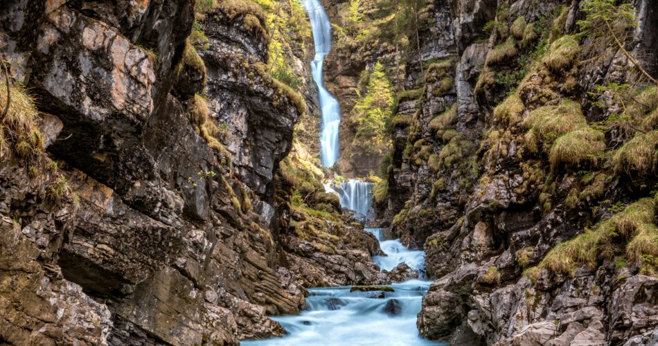 Imposanter Wasserfall inmitten einer Felsschlucht.